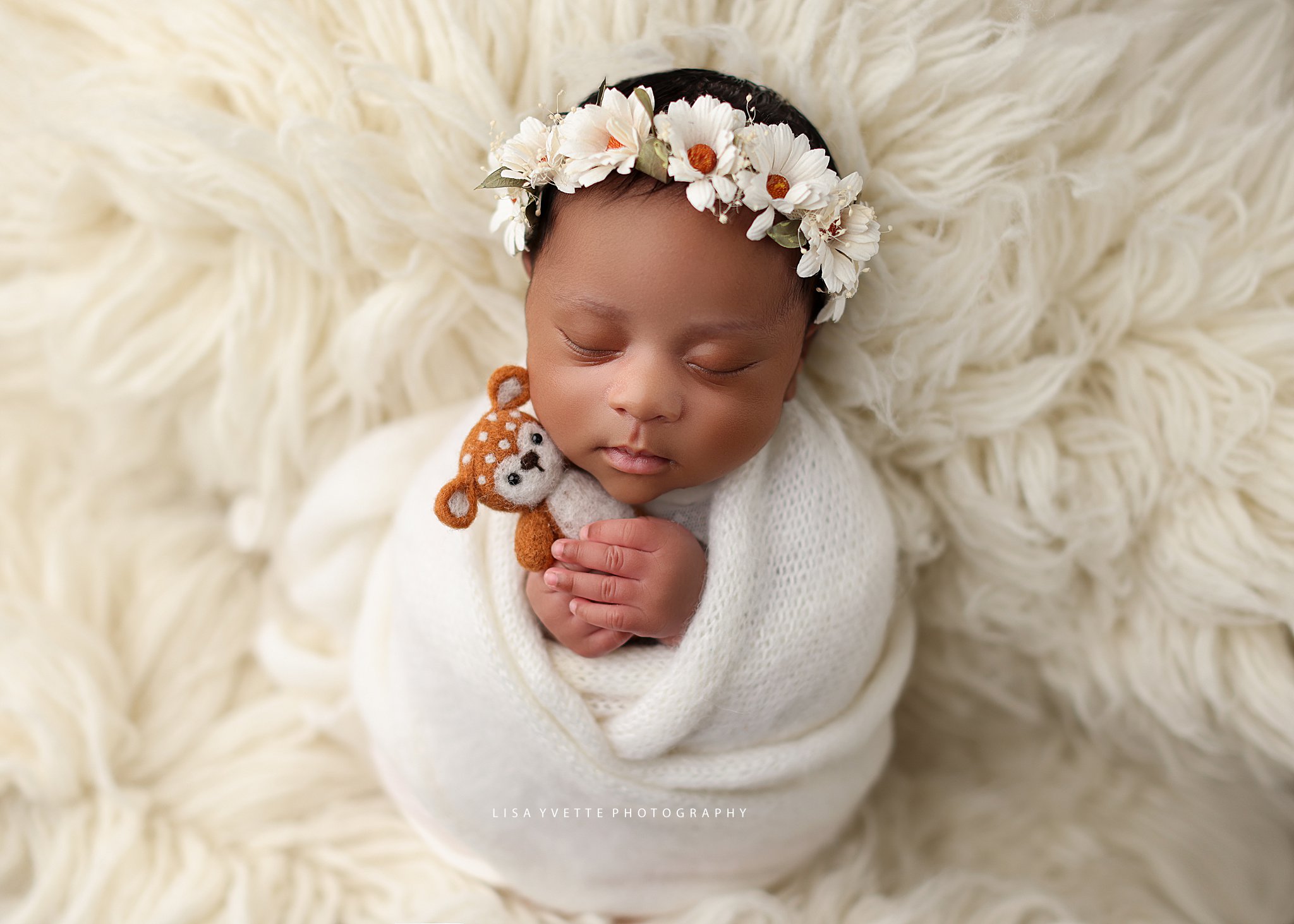 Swaddled African American Newborn with daisy headband and stuffed animal