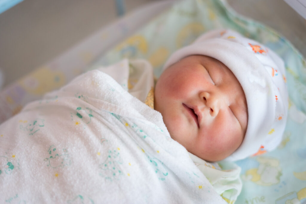 swaddled sleeping asian newborn