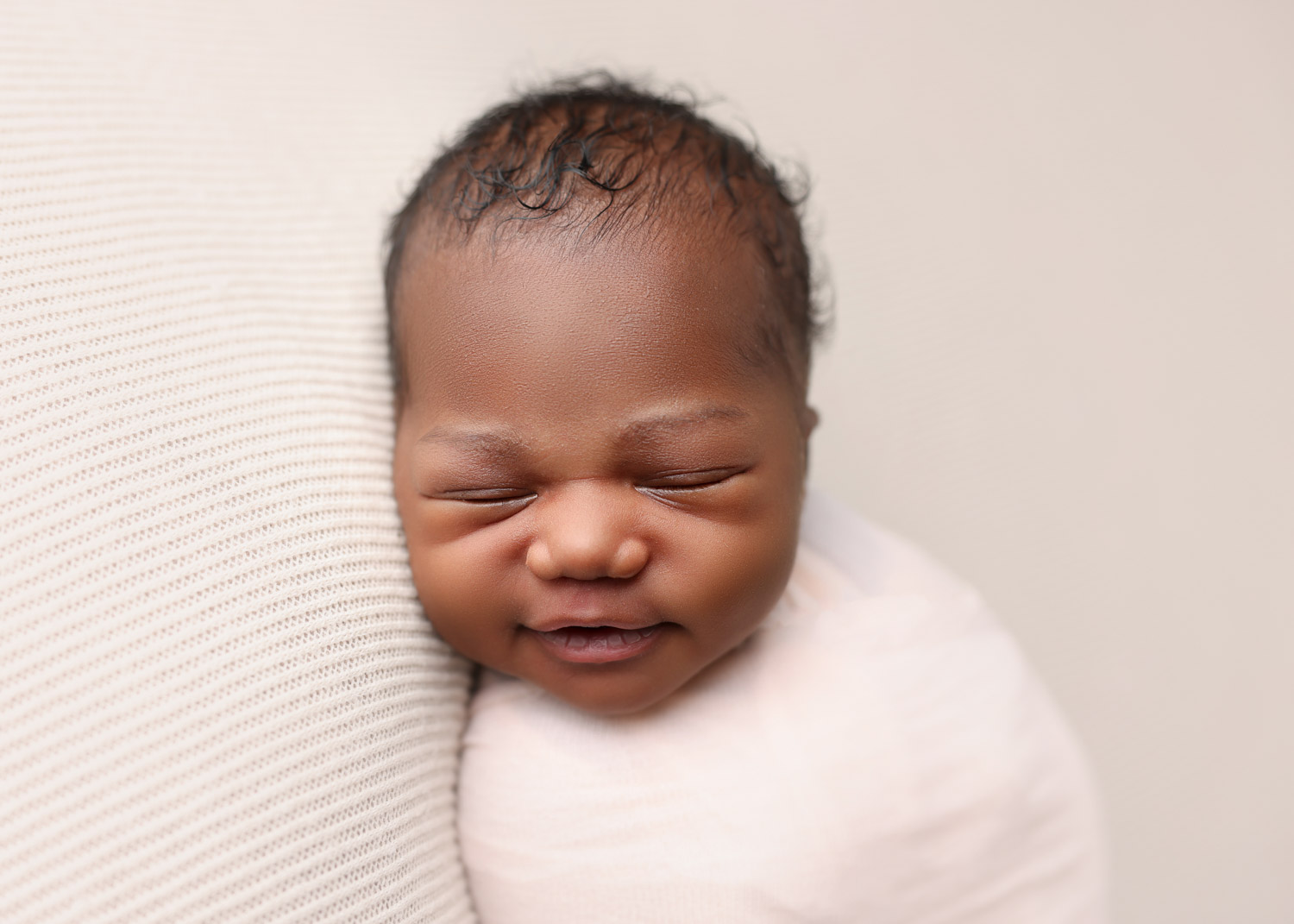 smiling swaddled african american baby boy