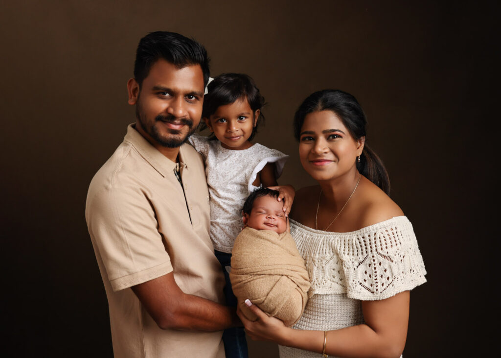 beautiful newborn indian boy with parents and sibling